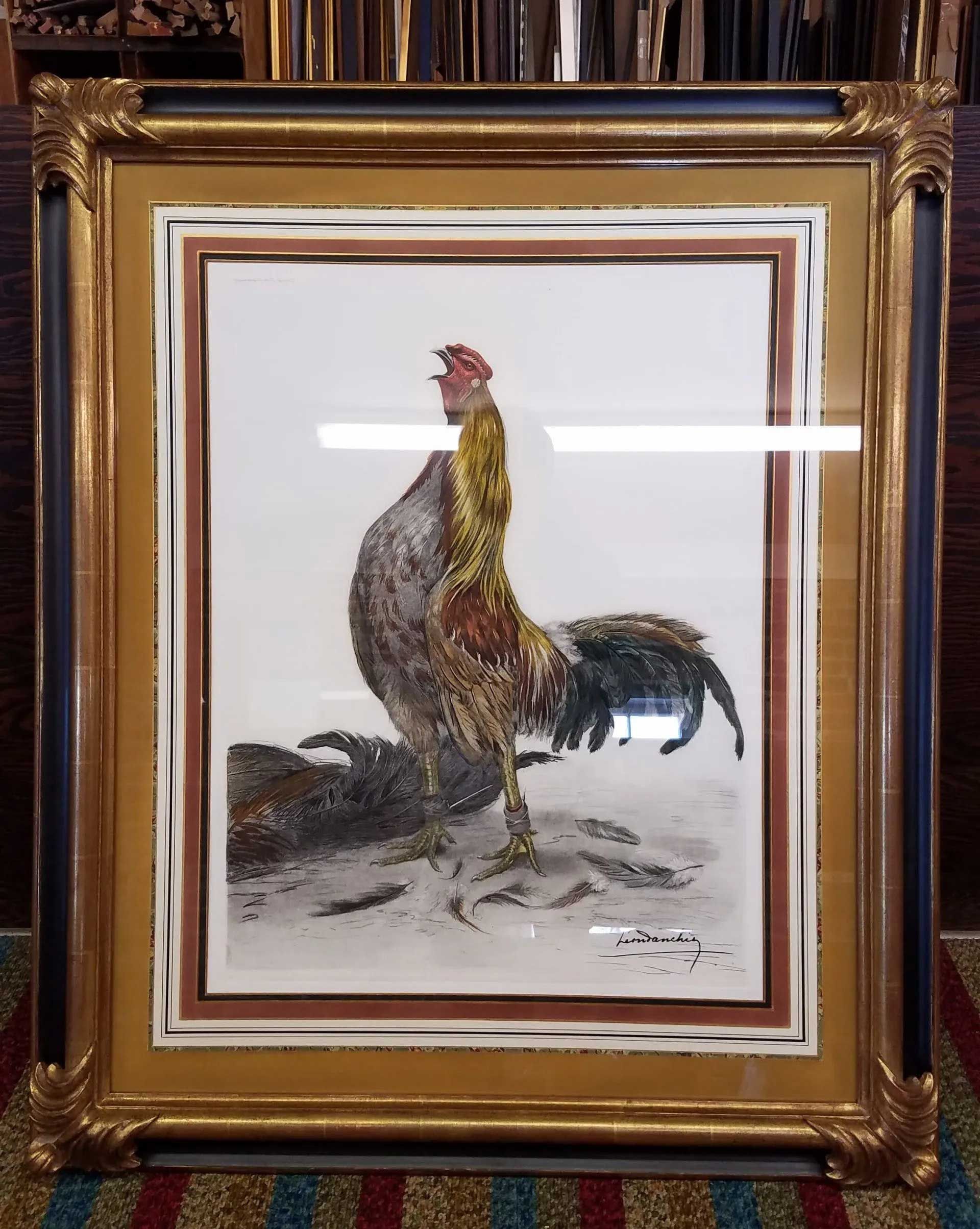 Framed watercolor painting of a rooster crowing, featuring warm gold and brown plumage, set against a plain background.
