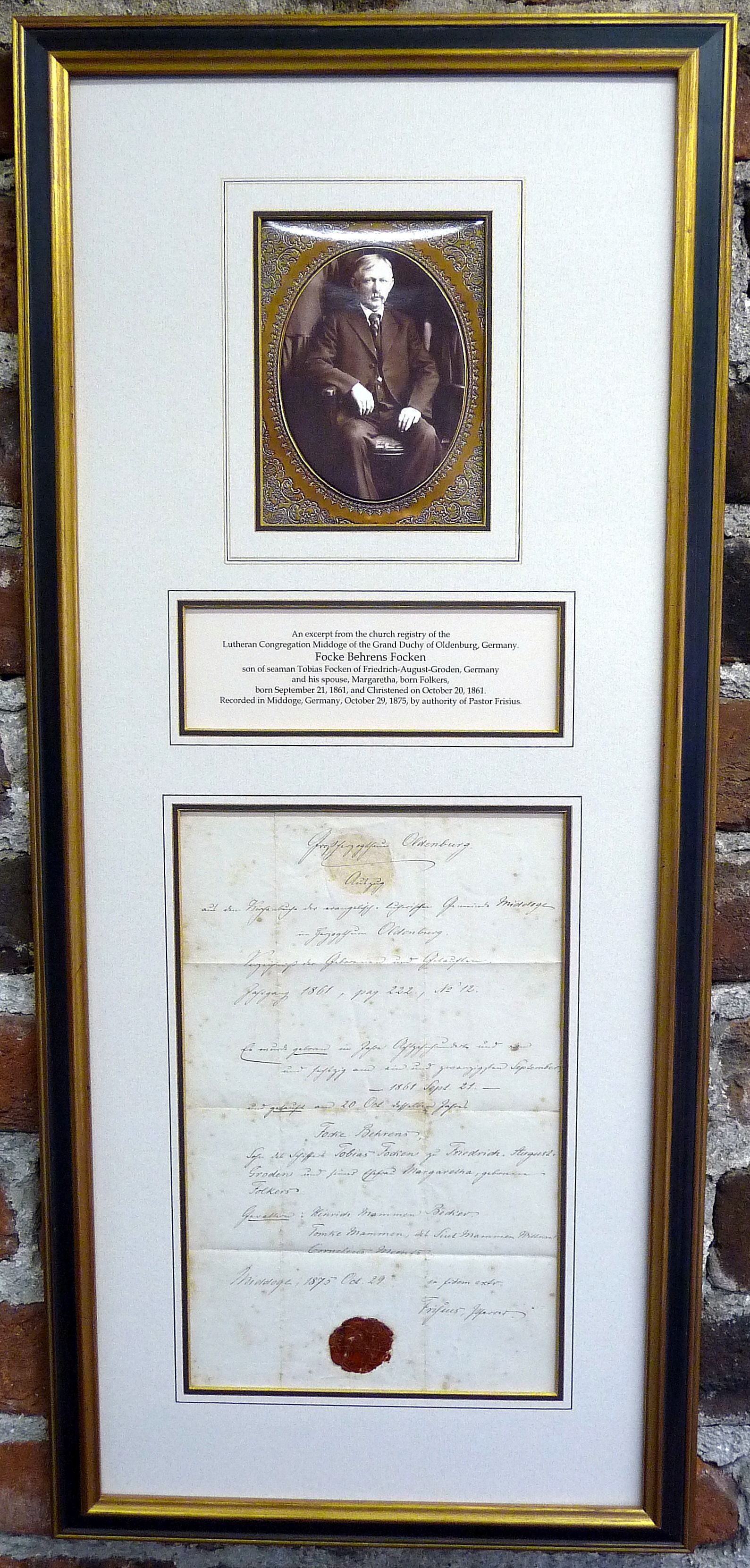 Framed document with a portrait medallion and certificate, mounted on a white mat with gold trim.