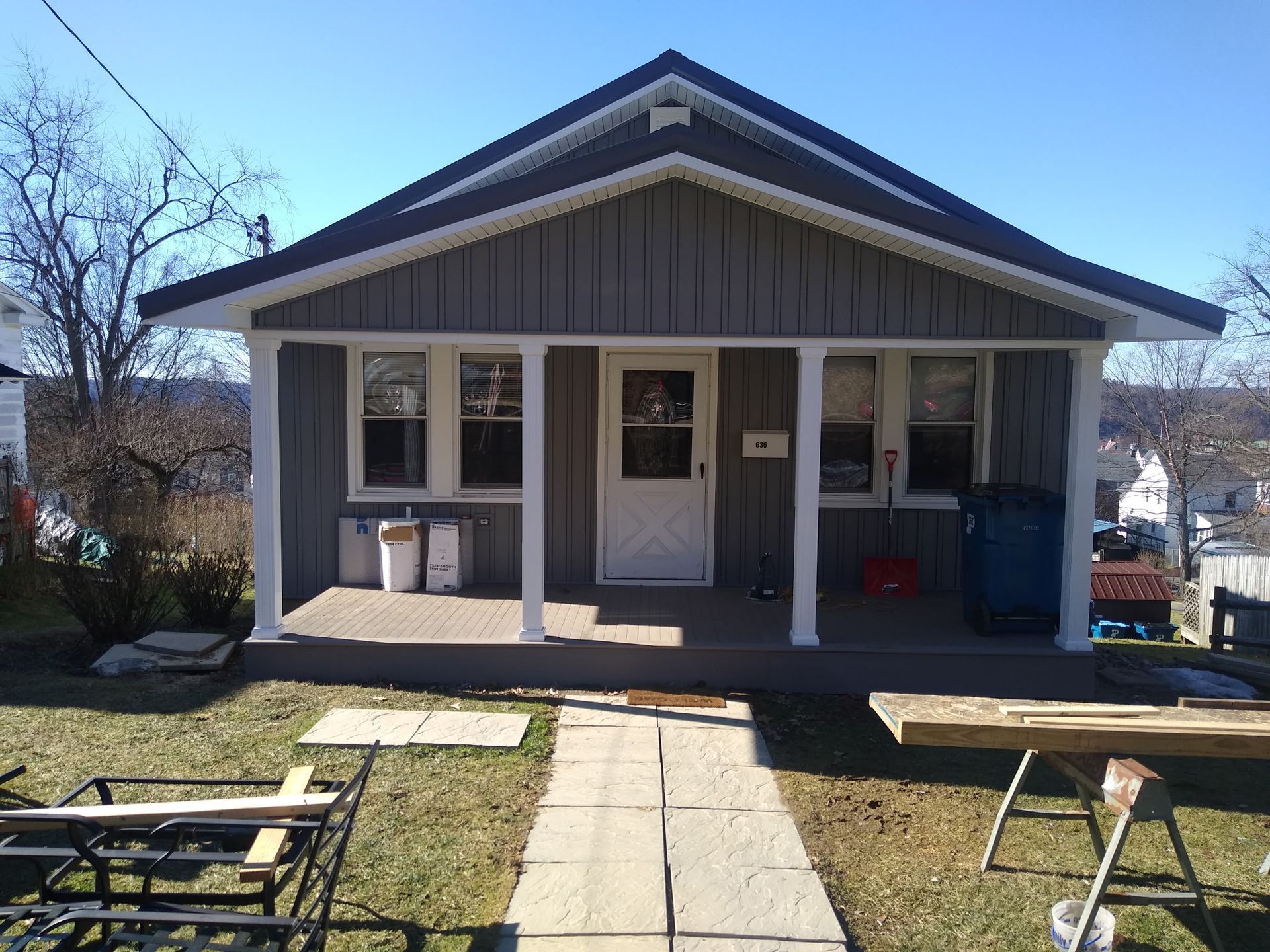 A small house with a porch and a walkway in front of it
