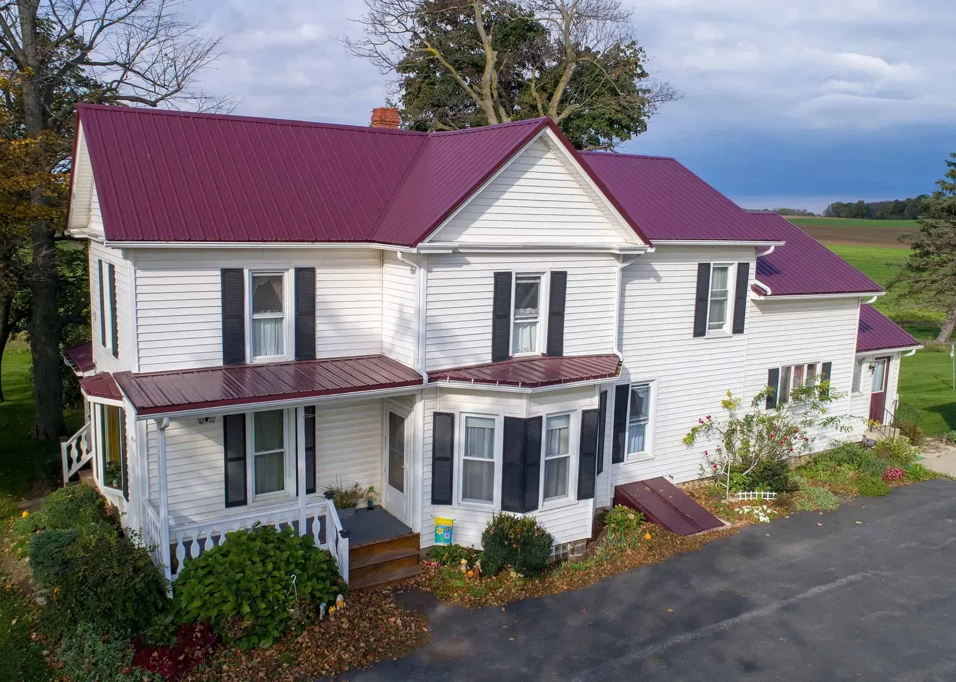 A white house with a purple roof and black shutters.