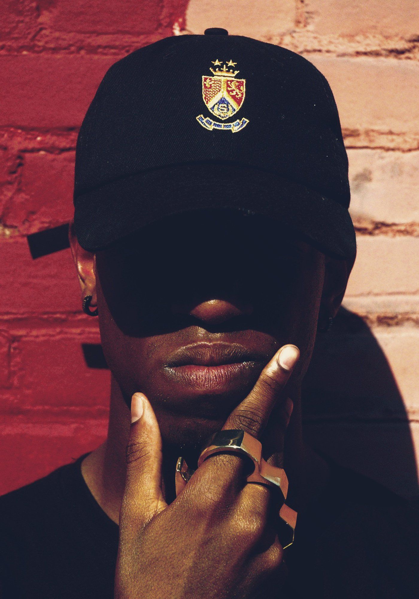 A man wearing a black hat with a coat of arms on it