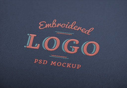 A mockup of an embroidered logo on a dark blue background.