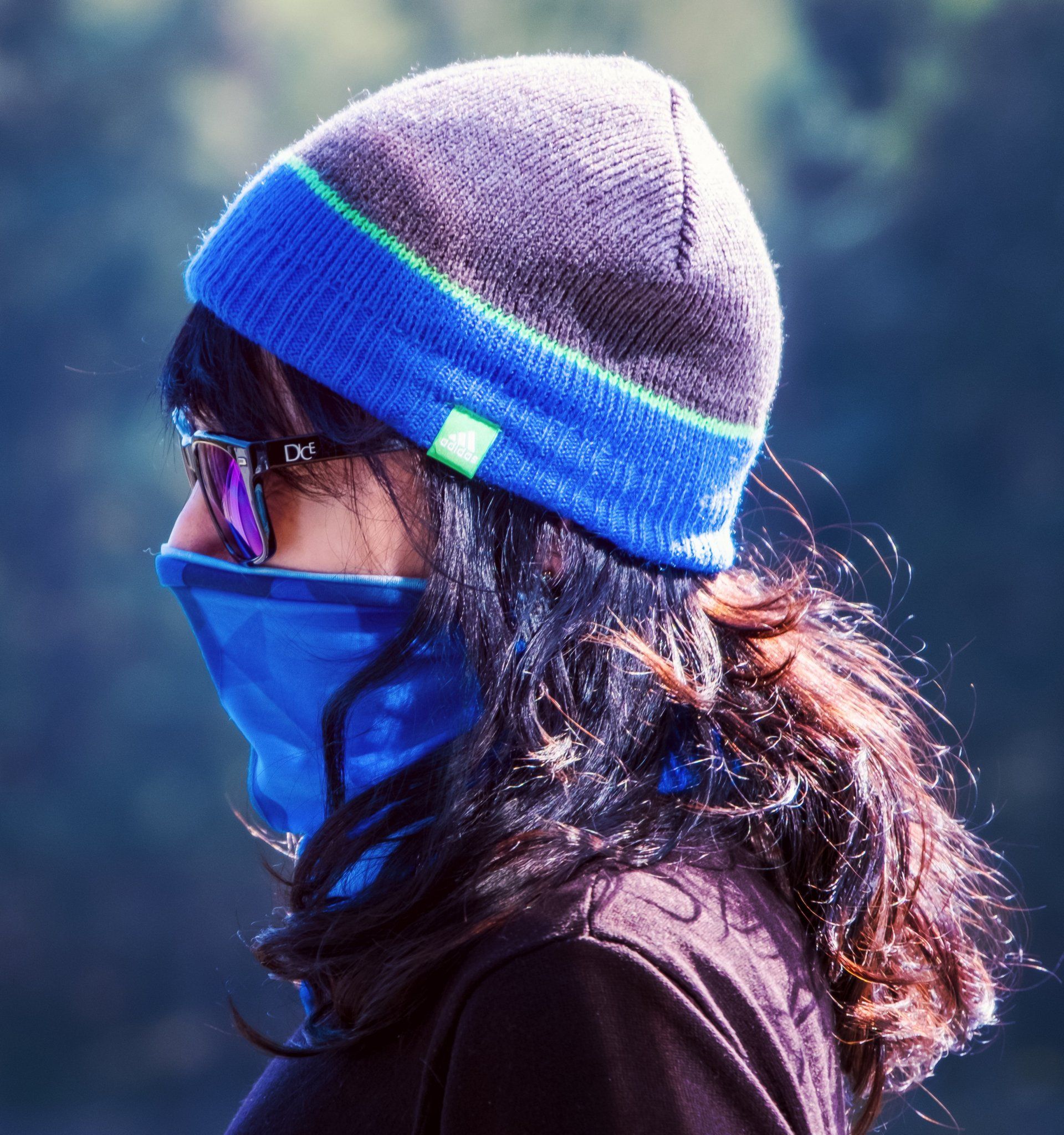 A woman wearing a blue beanie and sunglasses