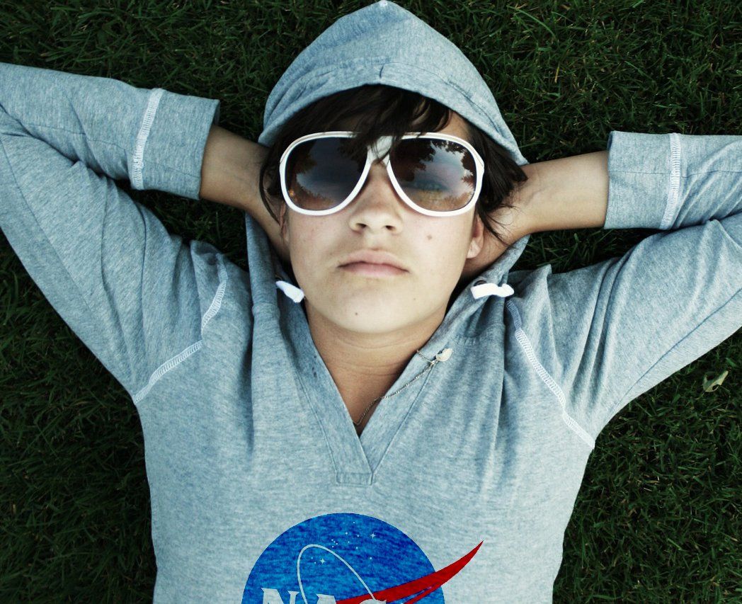 A person wearing sunglasses and a nasa shirt