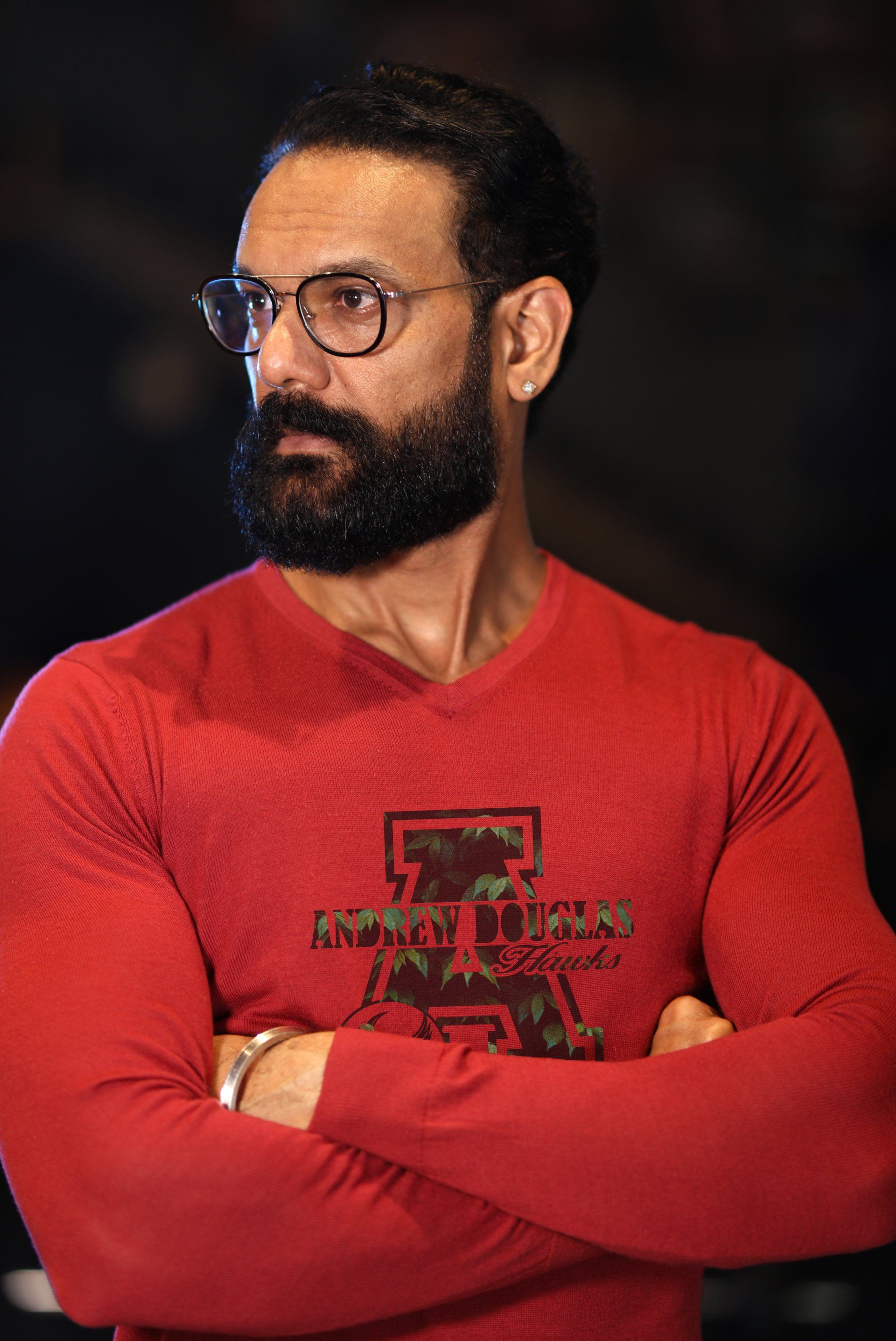 A man with a beard and glasses is wearing a red shirt.