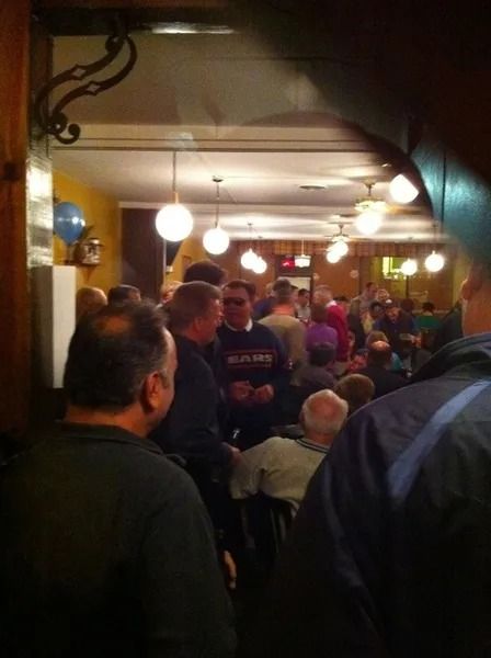 People gathered inside a dimly lit restaurant or bar, possibly socializing.