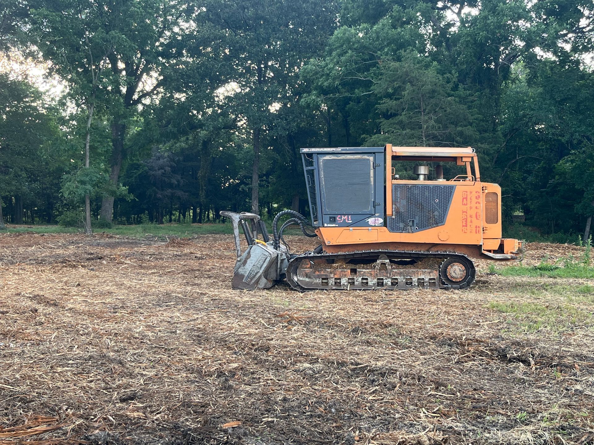 A bulldozer is sitting in the middle of a field.