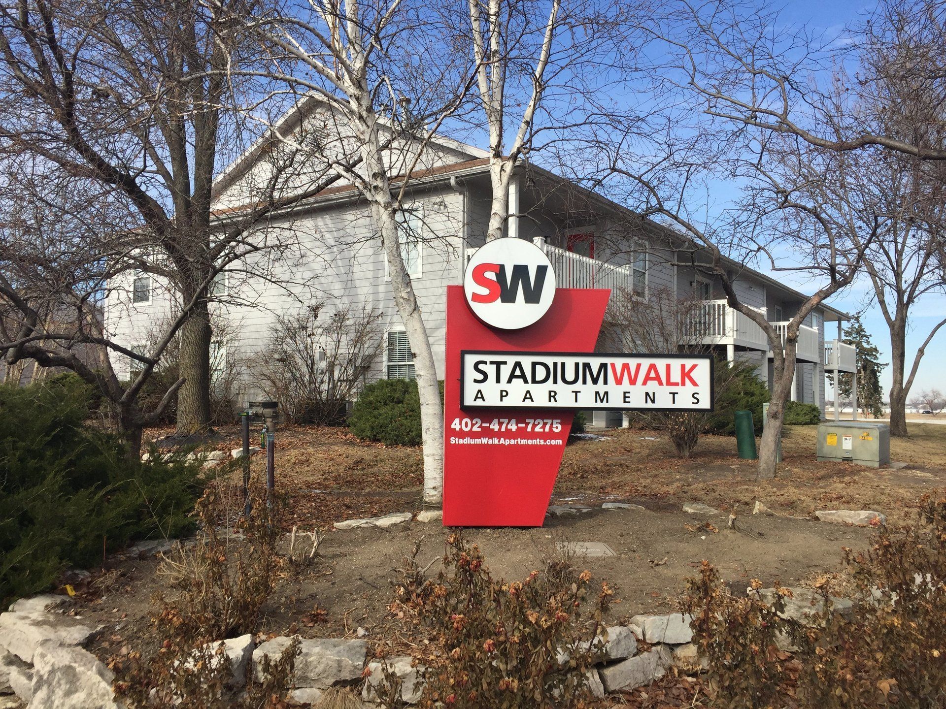 A sign for stadium walk apartments is in front of a building.