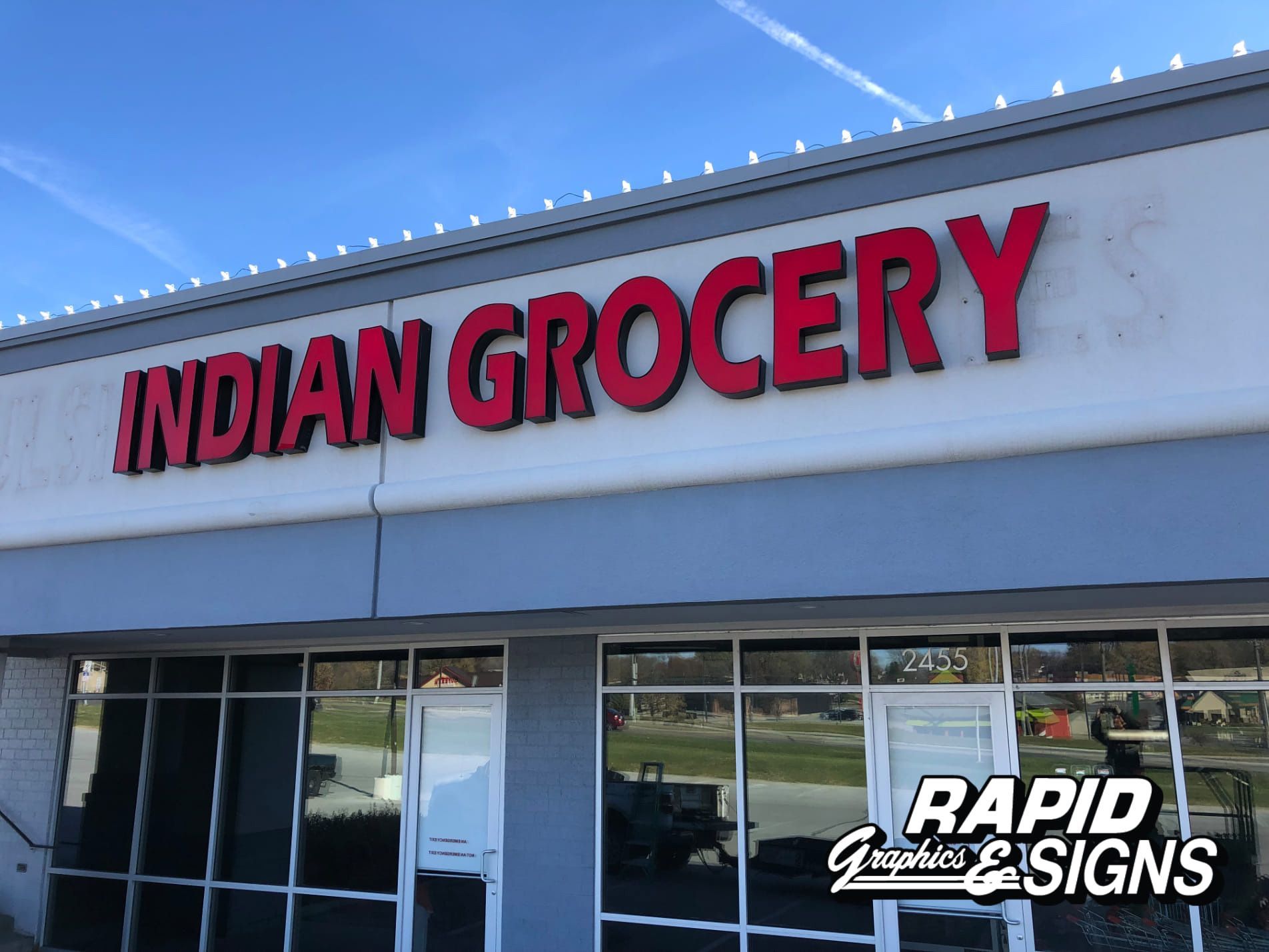 The front of an indian grocery store with red letters
