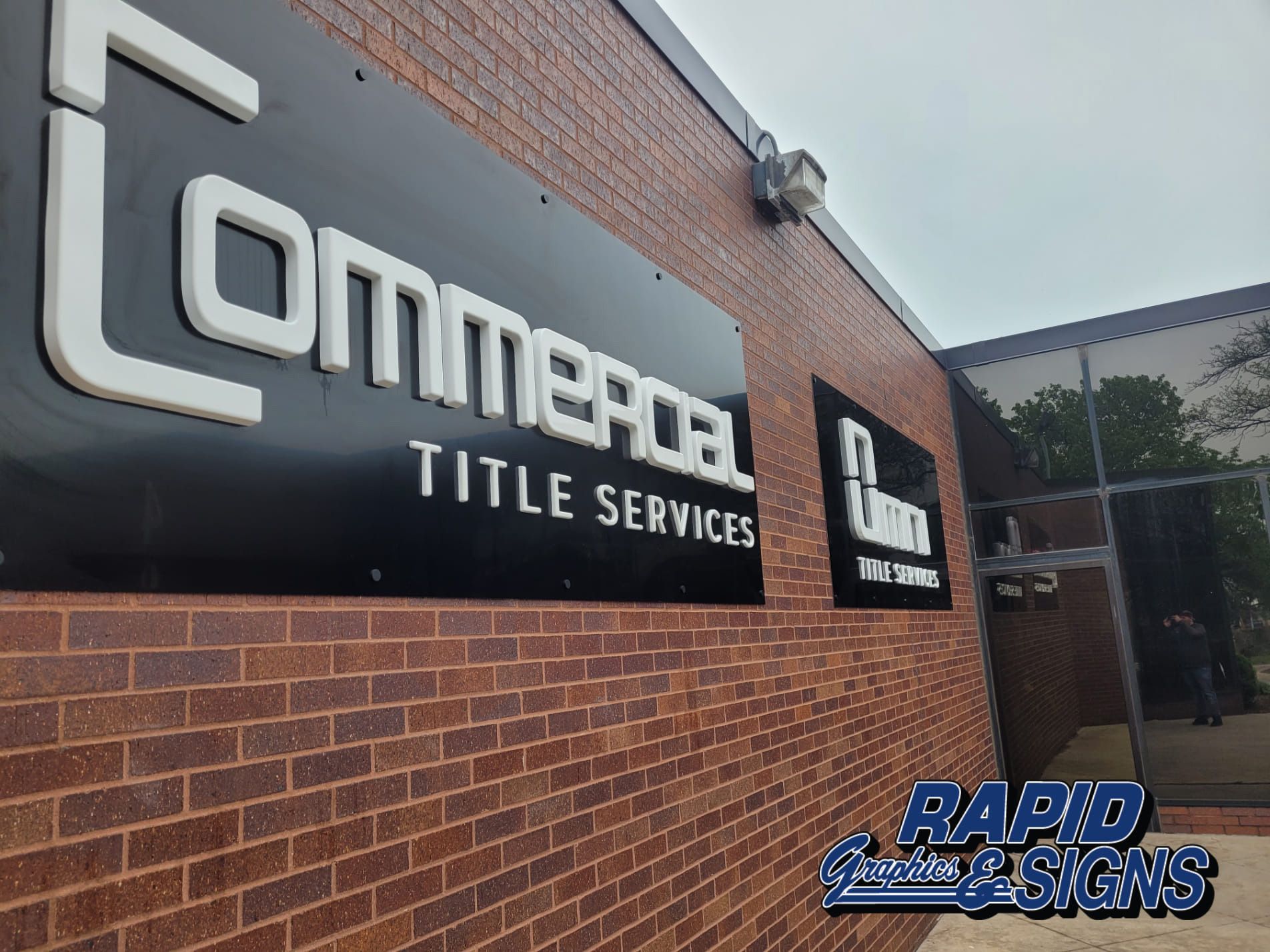 A brick building with a sign that says commercial title services