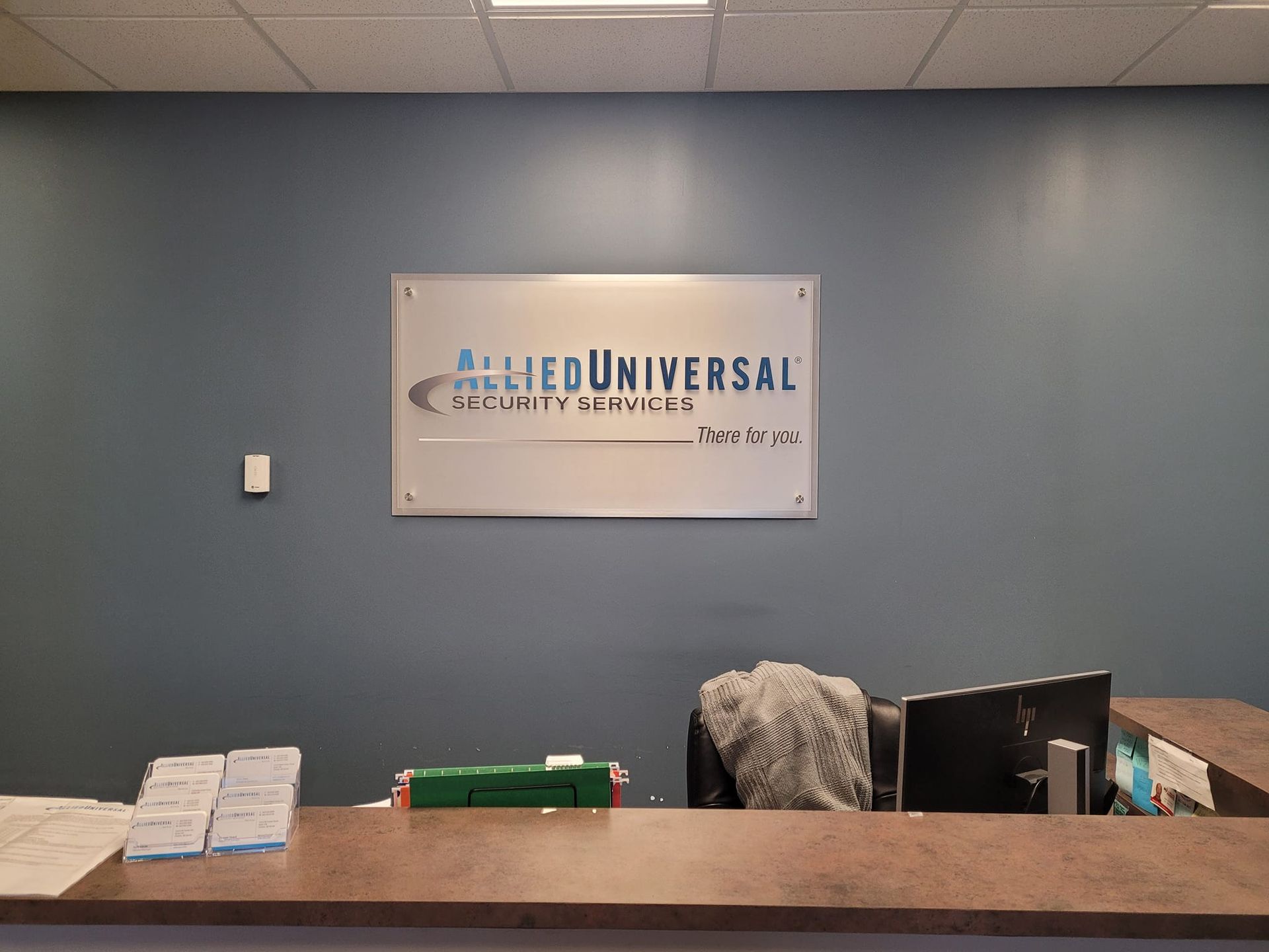 A reception desk with a sign above it that says universal security services