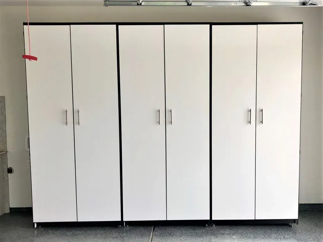 White garage storage cabinets against a light-colored wall, with silver handles.