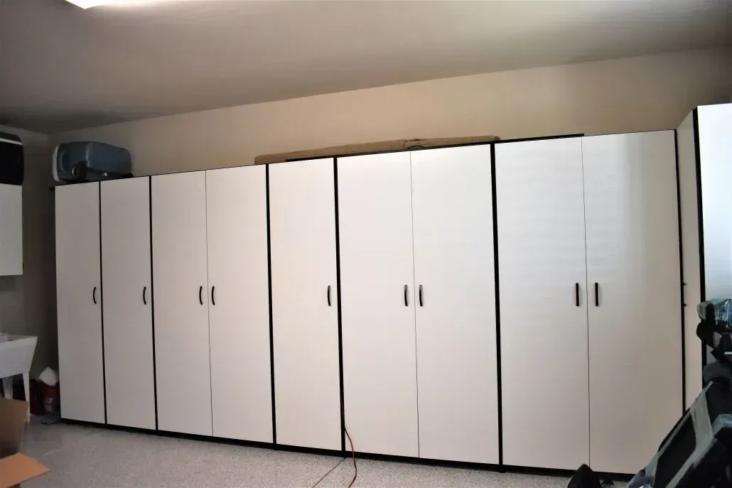 White storage cabinets line a garage wall.