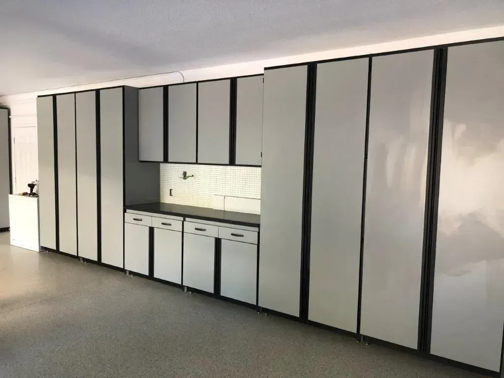 Garage cabinets, gray with black trim, line a garage wall.