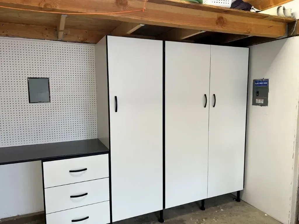 Garage storage cabinets: white doors, black handles, black trim, and drawers.