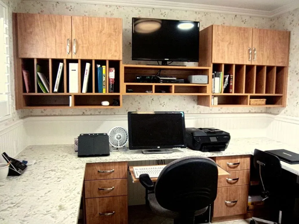 Home office with wooden cabinets, desk, computer, and printer.