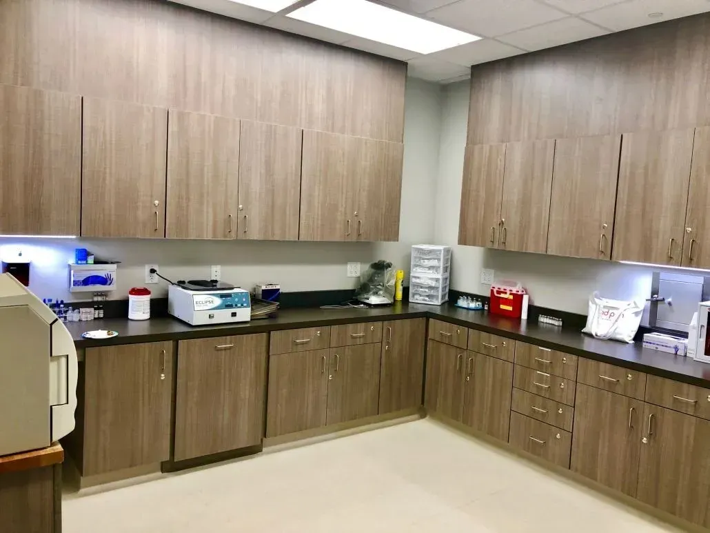Laboratory with brown cabinets and equipment, including a centrifuge and testing supplies.