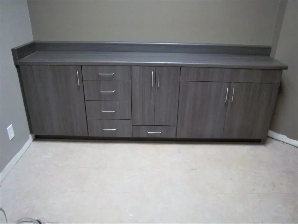 Gray cabinets with a countertop against a beige wall and floor.
