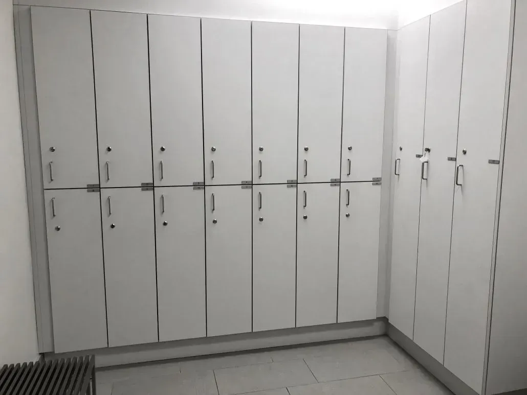 White lockers line a wall in a room.
