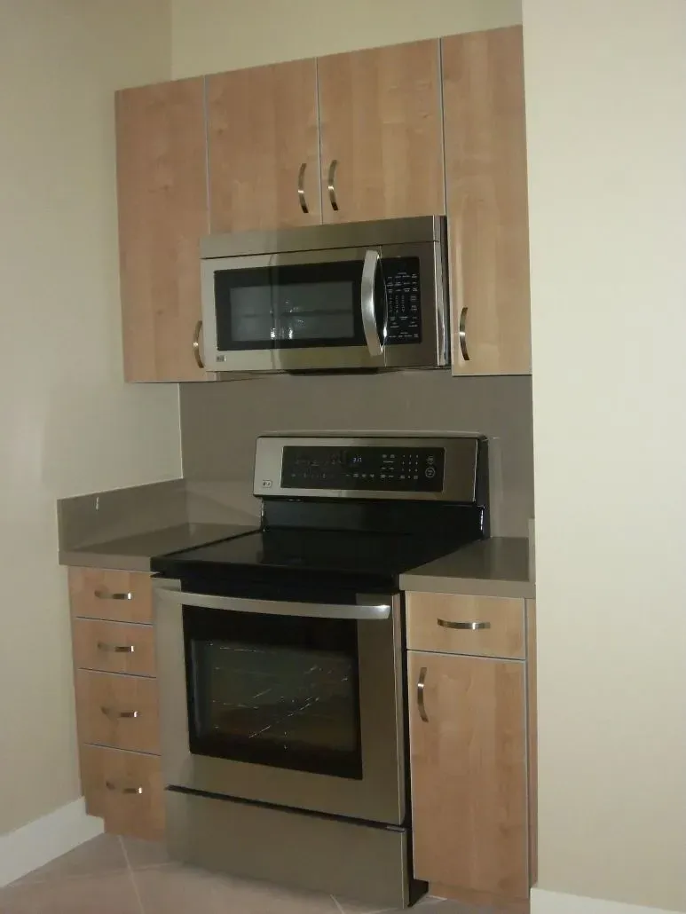 Kitchen with a microwave above a stove; light wood cabinets, stainless steel appliances.