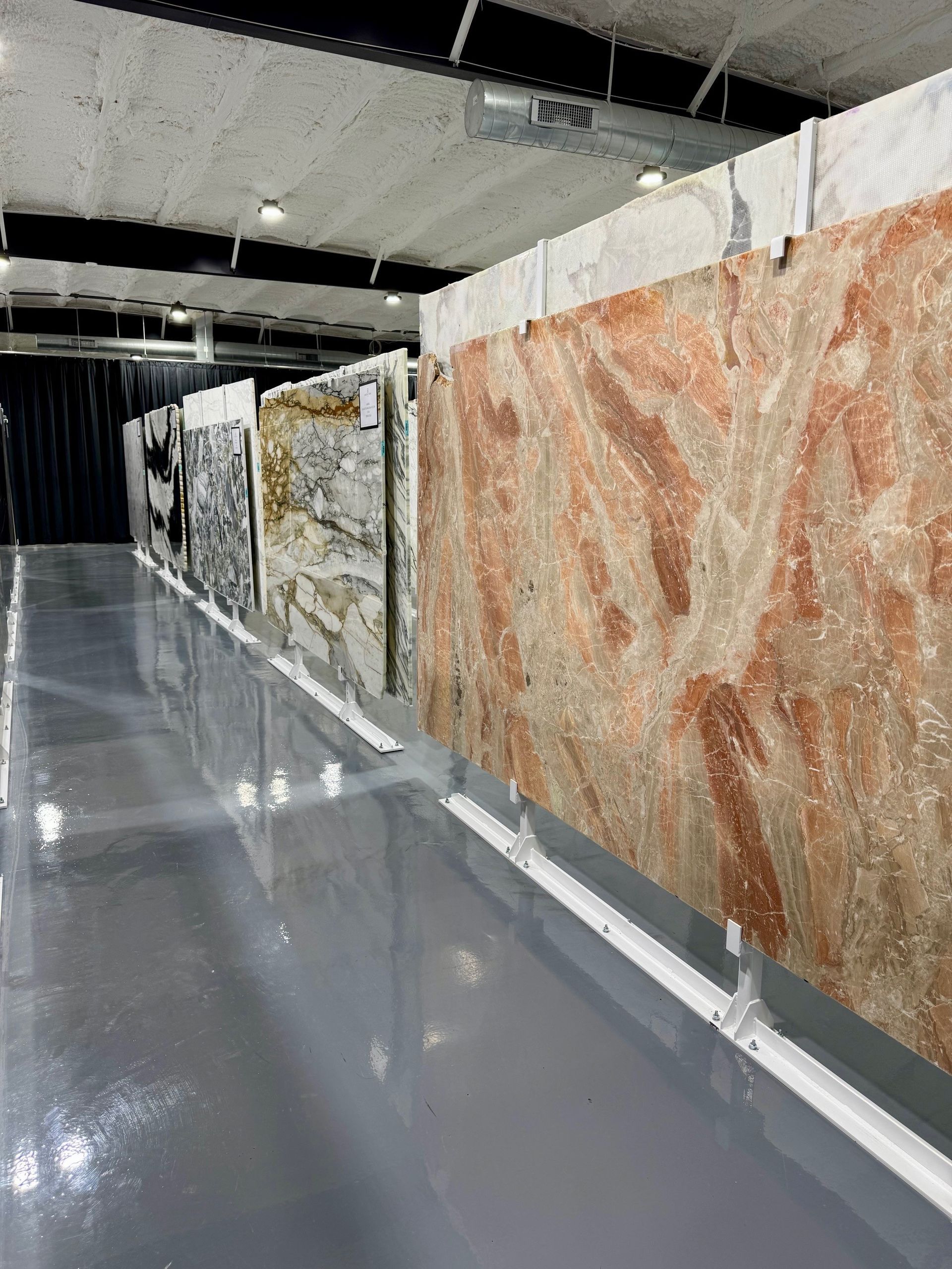 A warehouse filled with lots of different types of marble slabs.
