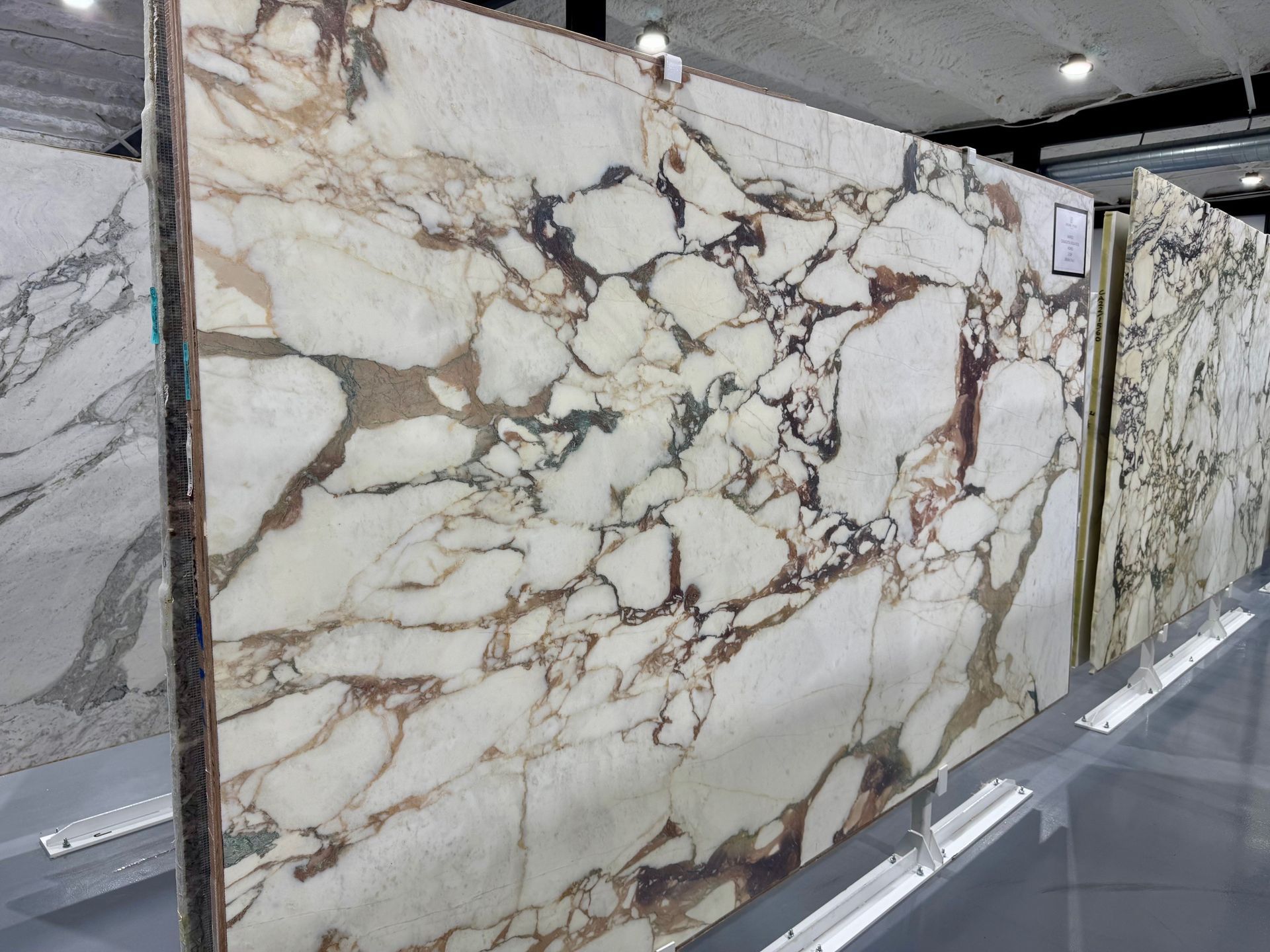 A row of marble slabs are lined up in a store.