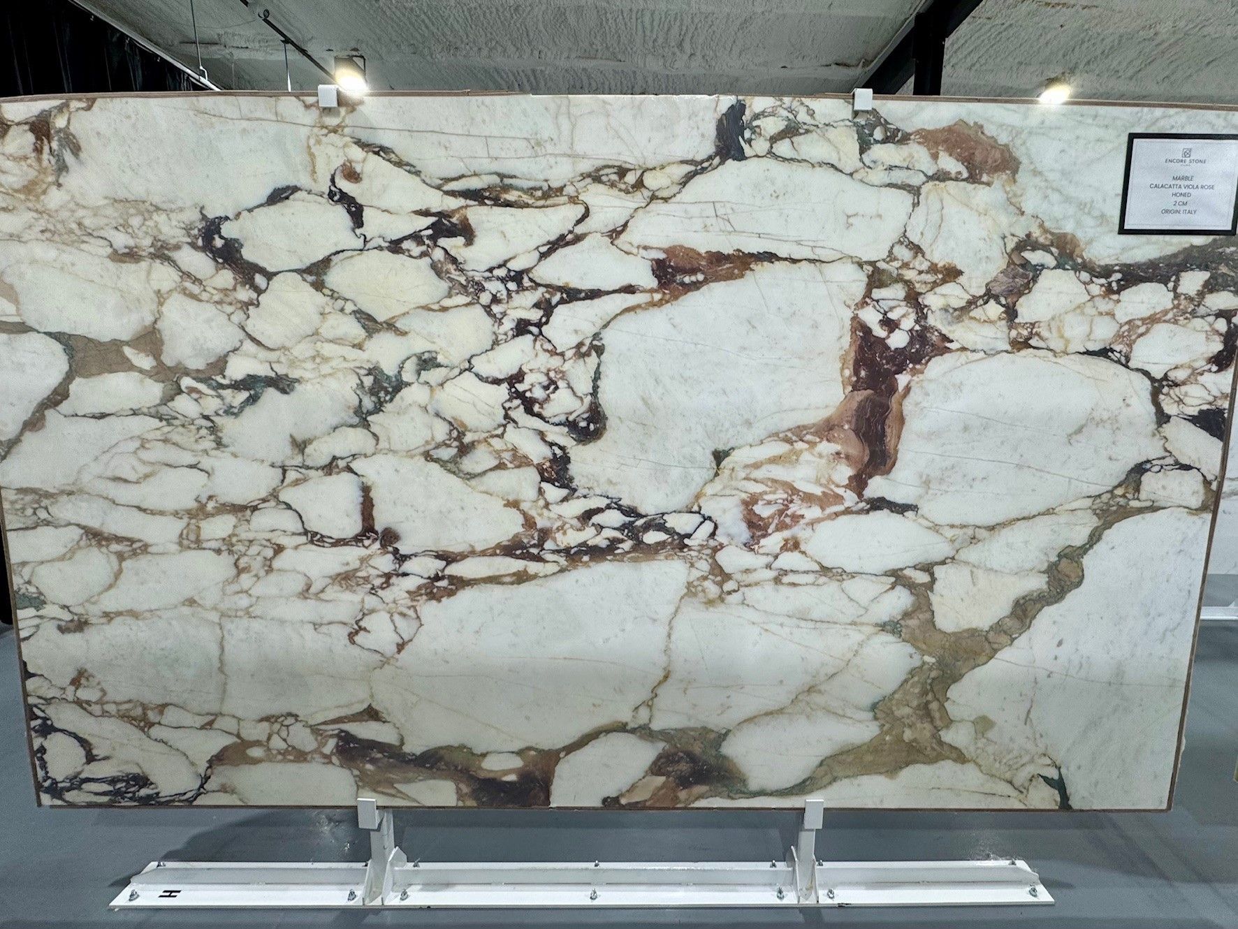 A large piece of marble is displayed on a stand
