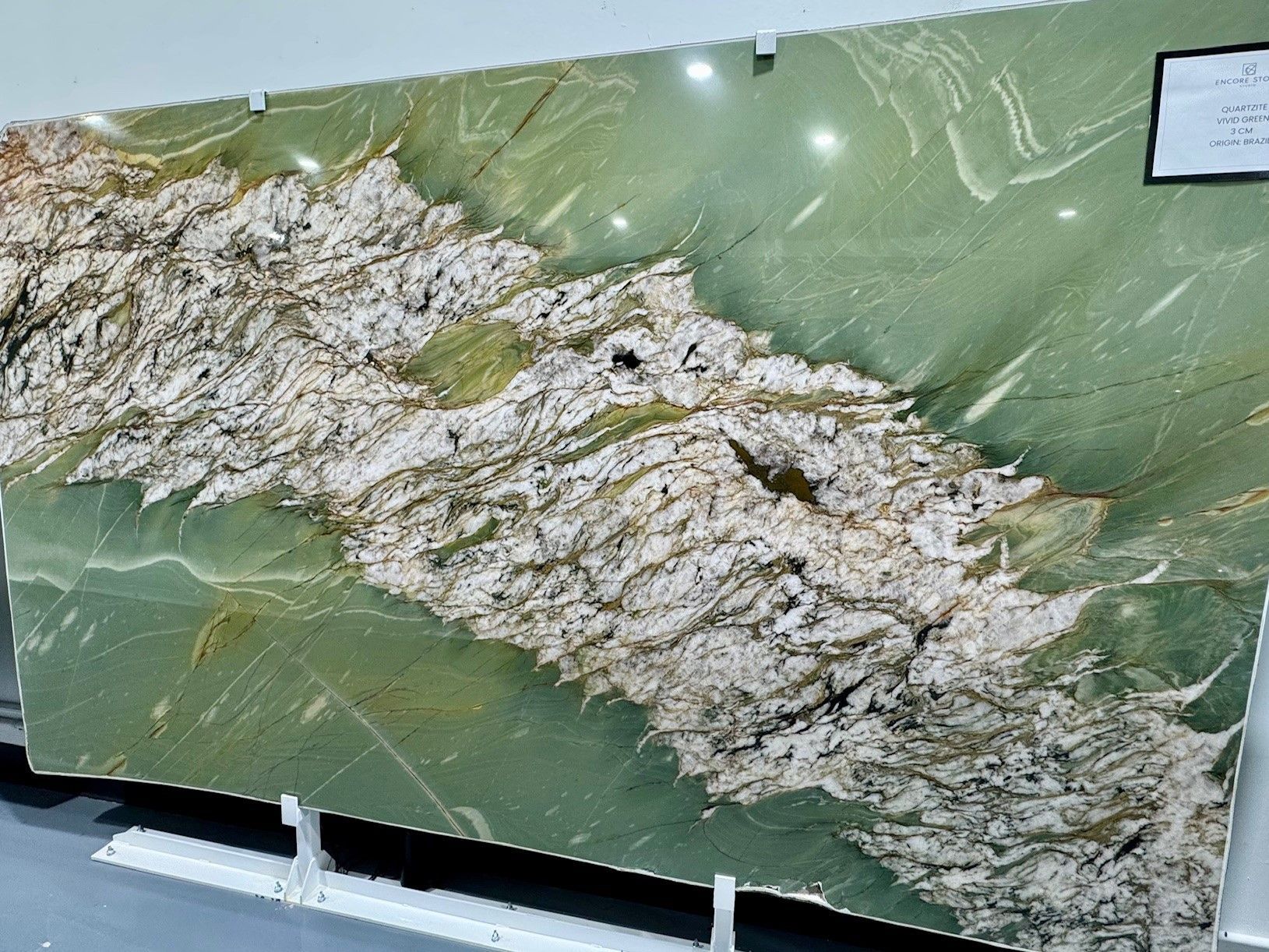 A green and white granite slab is sitting on a table.
