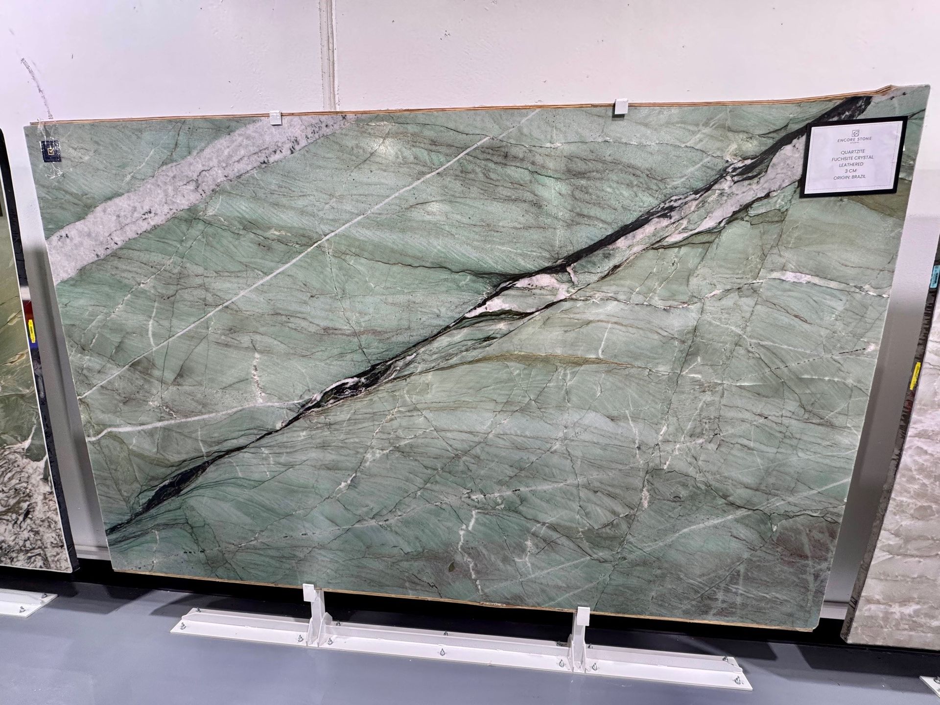 A green marble slab is sitting on top of a cement floor.