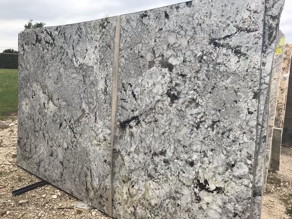 A large slab of granite is sitting on top of a pile of rocks.