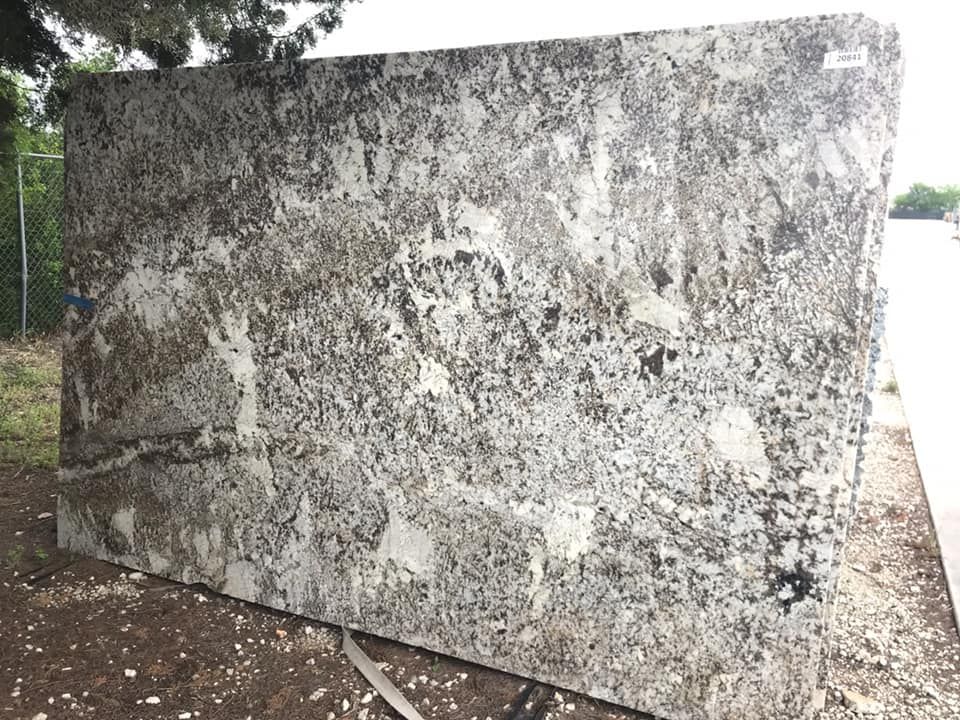 A large piece of granite is sitting on the ground.