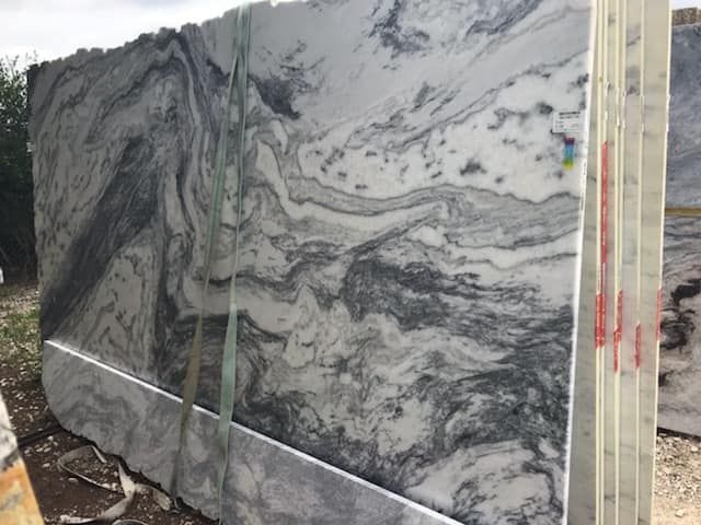 A large slab of marble is sitting on top of a pile of marble.