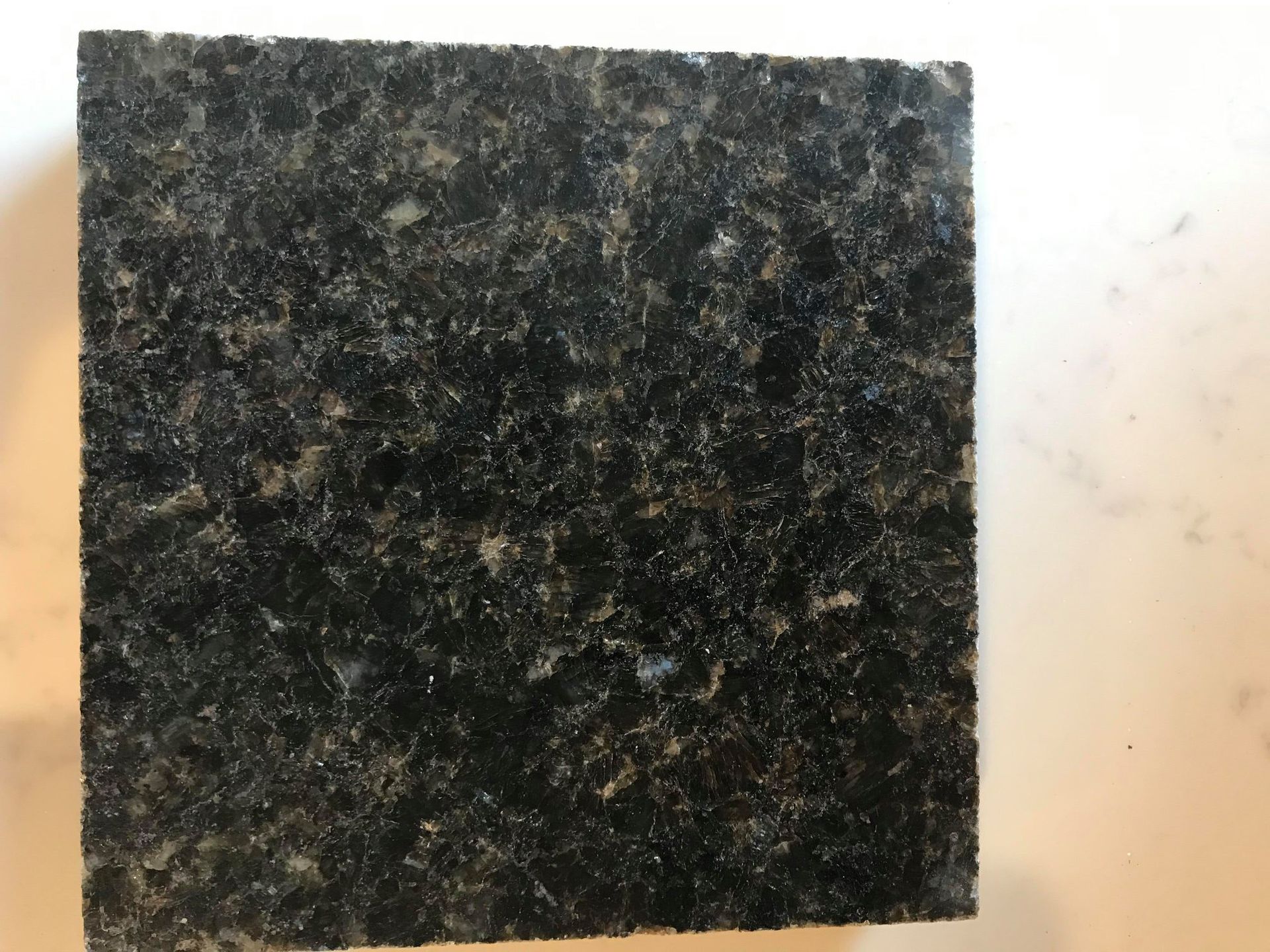 A piece of black granite is sitting on a white surface