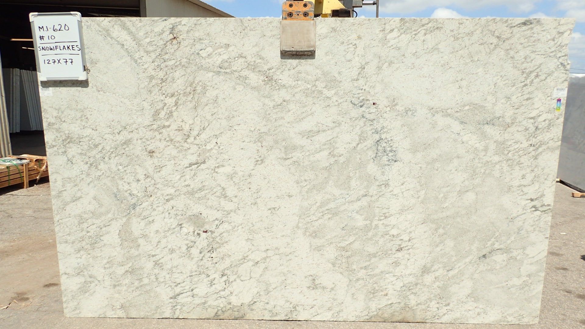 A large slab of white granite is sitting on the ground