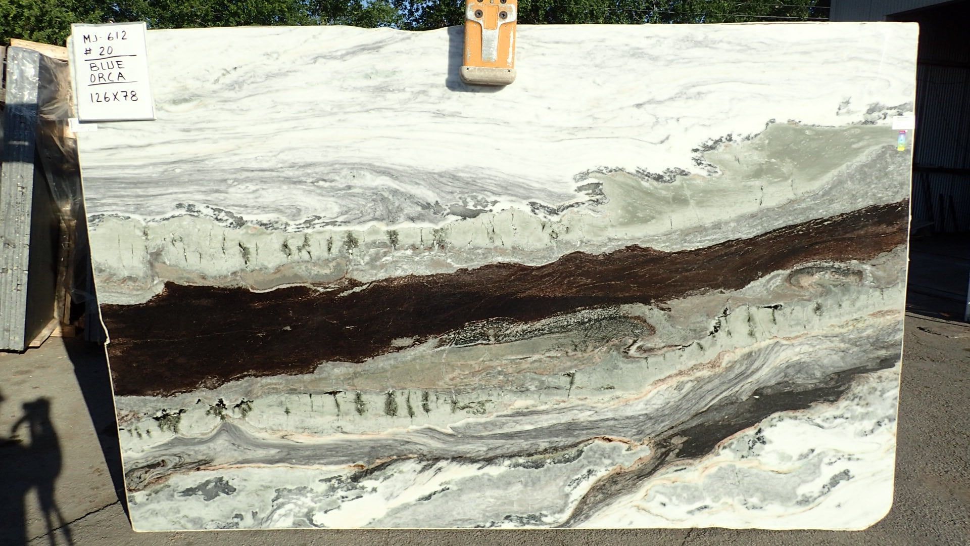 A large slab of granite is sitting on the ground.