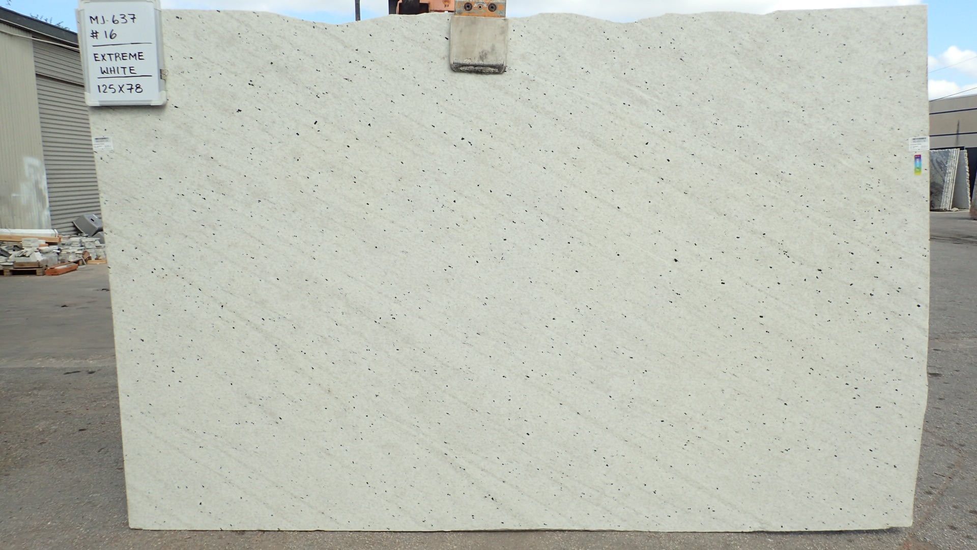 A white granite slab is sitting in a parking lot