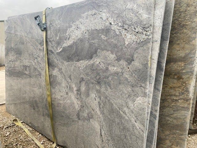 A stack of gray granite slabs with a measuring tape attached to them.