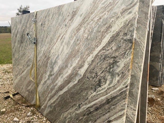 A stack of marble slabs sitting on top of each other in a field.