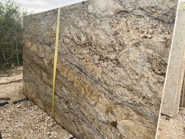 A large slab of granite is being measured with a tape measure.