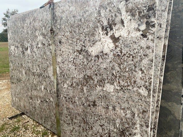 A large slab of granite is sitting on top of a pile of gravel.