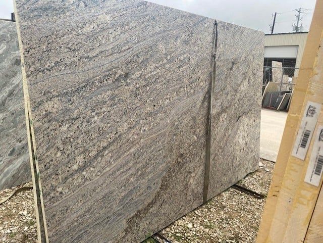 A large slab of granite is sitting on top of a pile of gravel.