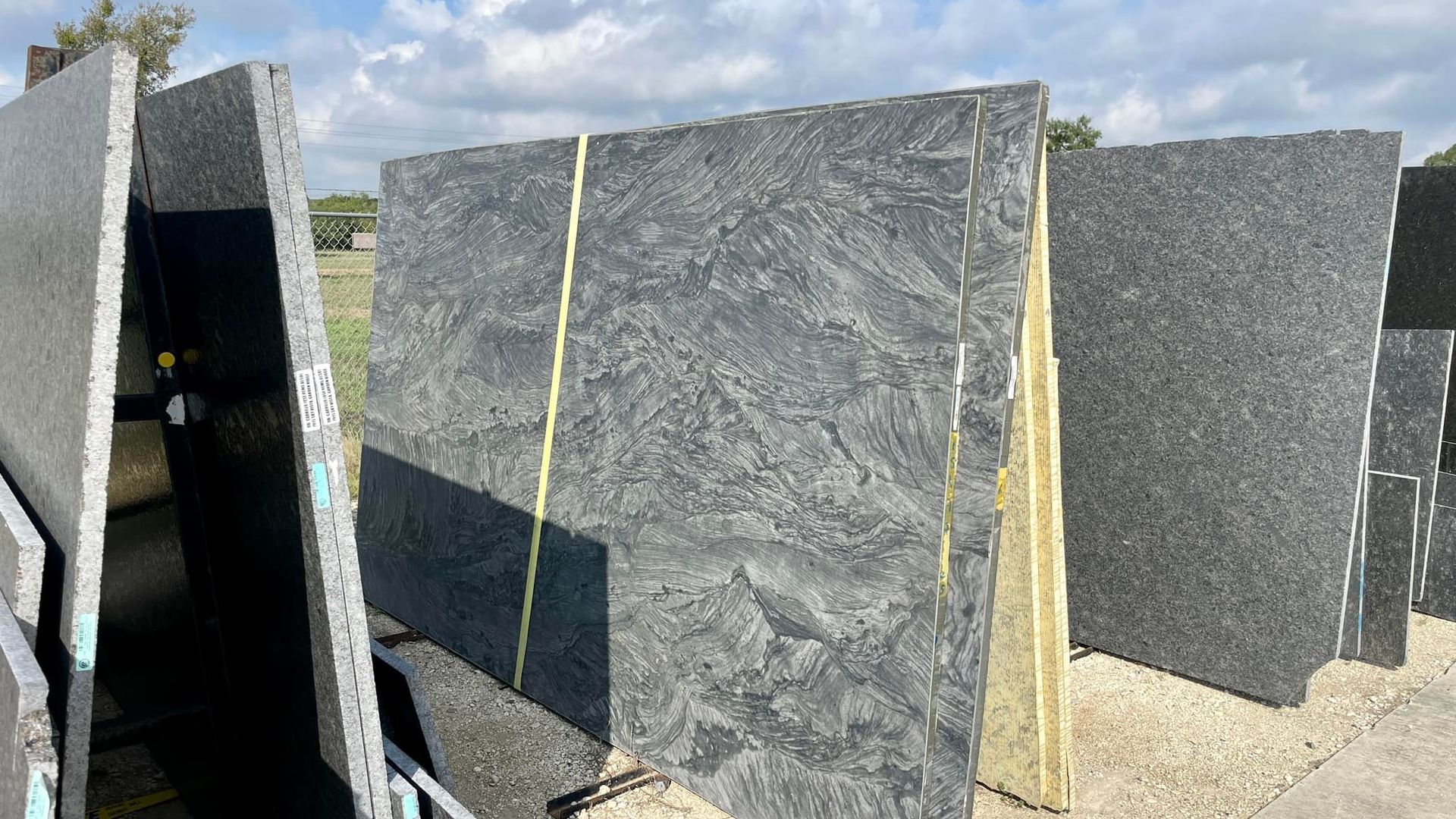 A bunch of black granite slabs are stacked on top of each other.