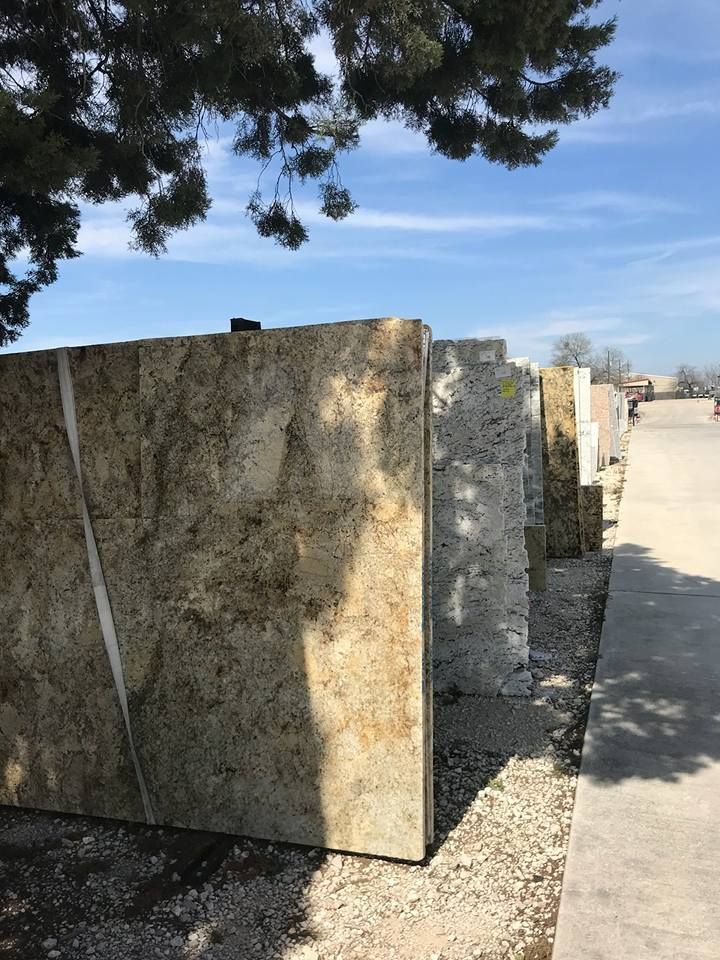 A row of marble slabs are lined up in a yard