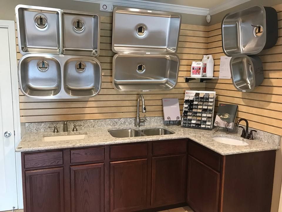 A kitchen with stainless steel sinks and wooden cabinets