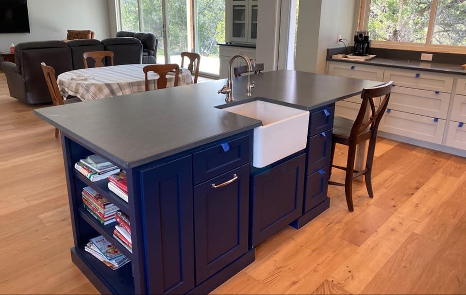 A kitchen with blue cabinets and a white sink