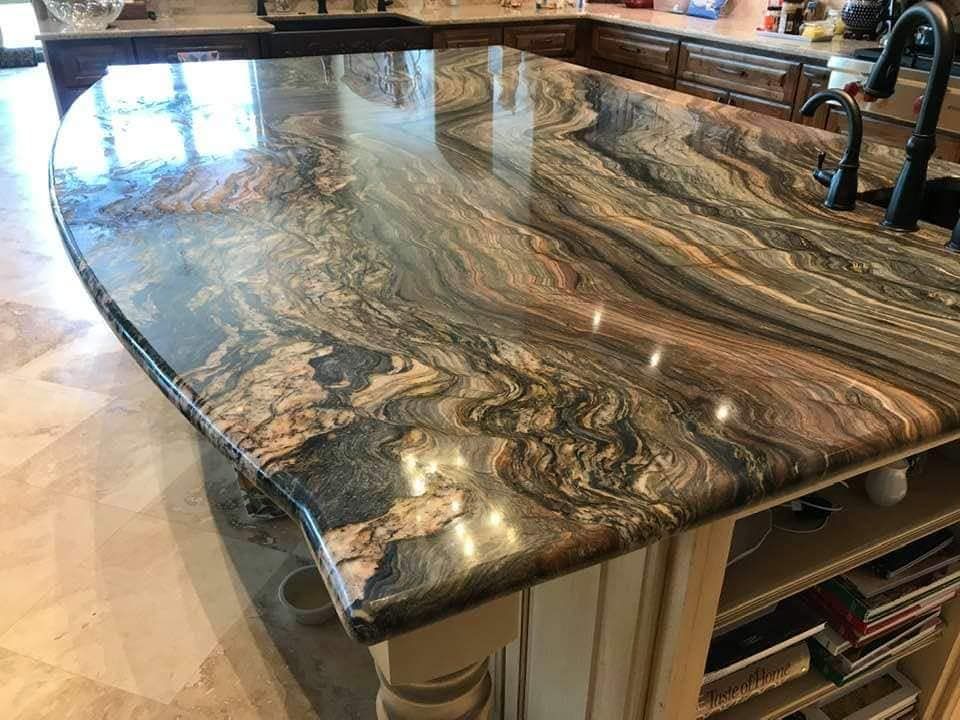 A kitchen with a large granite counter top and a sink.