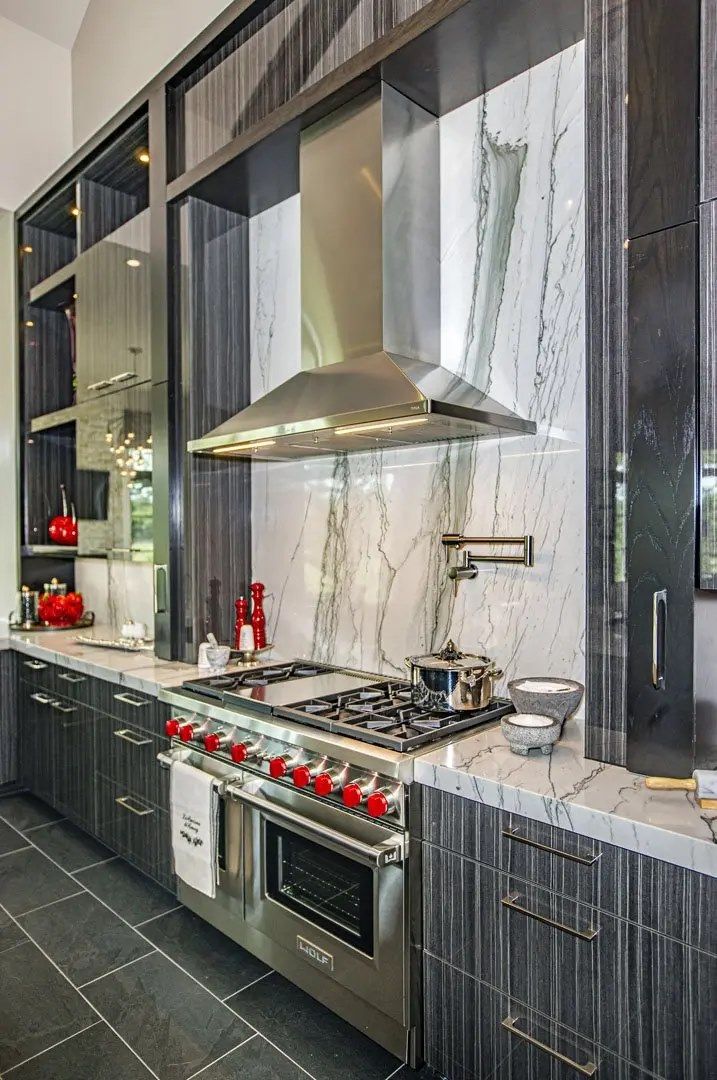 A kitchen with stainless steel appliances and marble counter tops.