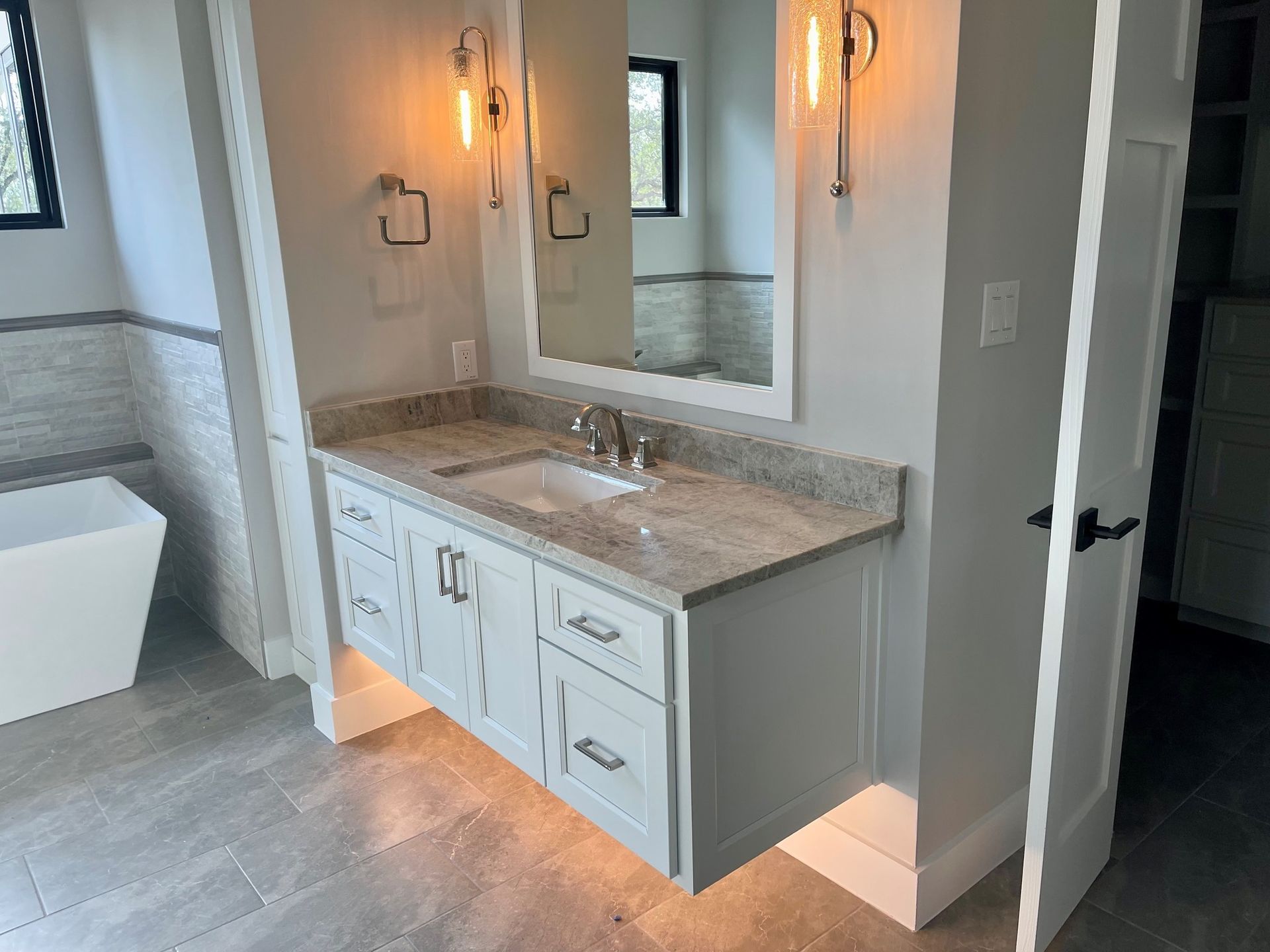 A bathroom with a sink , mirror and tub.