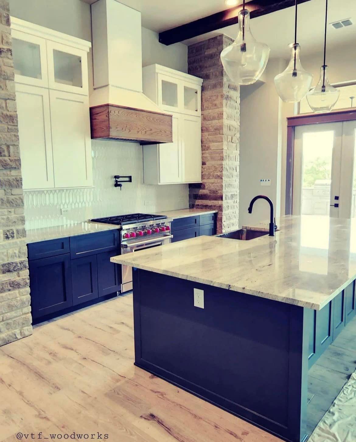A kitchen with a large island and a stove top oven