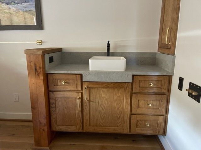 A bathroom vanity with a sink and wooden cabinets
